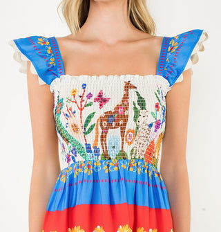 Closeup of the fluttery cap sleeves and smocked bodice with animal designs on a dress featuring a Scandinavian folk art -inspired design aesthetic