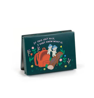 Flat dark green rectangular box featuring whimsical illustration of a squirrel wearing a red backpack among anthropomorphic mushrooms says, "If this isn't nice, I don't know what is."