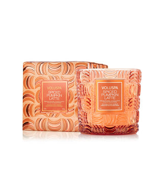 Orange embossed glass Voluspa Spiced Pumpkin Latte candle vessel next to its matching gift box