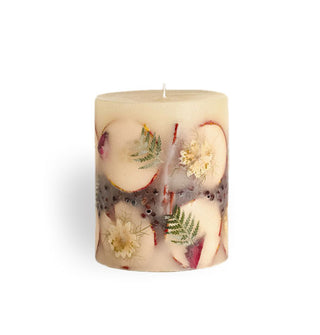 Whitish single-wick pillar candle with inlaid apple slices, flowers, ferns, and berries