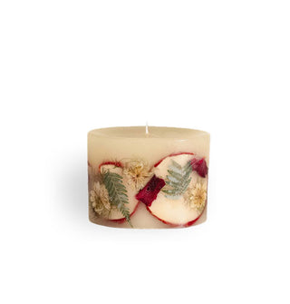 Short, whitish, single-wick pillar candle with inlaid apple slices, flowers, and ferns