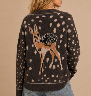 Model facing away from the camera wears a brown cardigan with deer fawn design on the back surrounded by light spots all over the bodice and sleeves