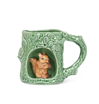 Green mug with rustic texture and tree branch designs features a circular alcove with a brown squirrel figurine inside