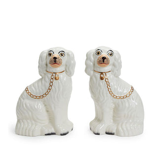 Pair of white ceramic antique-style Staffordshire dog status with gold collar and chain leash details, painted facial features, and darkened paw tips