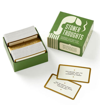 Components of the Stoner Thoughts game: opened box that reveals stacks of cards inside, and two pulled sample cards set aside
