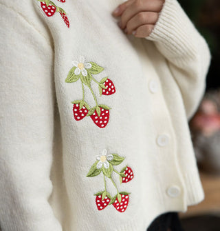 Closeup of the strawberry embroidery on a white cardigan