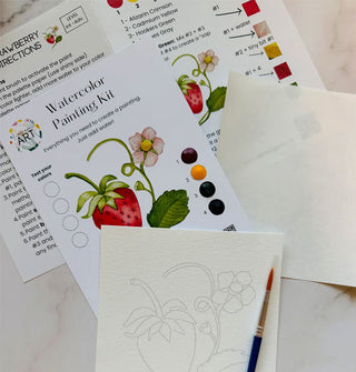 Components of a Strawberry Watercolor Painting Kit on a marble tabletop