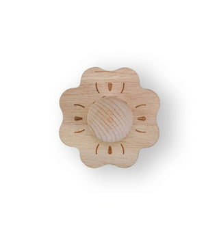 Top view of a round wooden brush with knob handle is shaped and stained to look like a flower