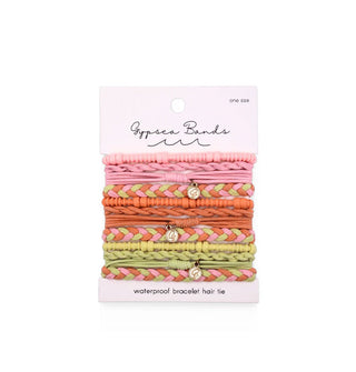 Set of woven Gypsea Bands Waterproof Bracelet Hair Ties in pink, orange, and lime green tones, three of which feature gold charms