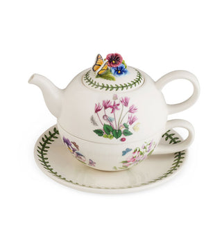 Stacked white saucer, teacup, and teapot set with floral and vine designs and figural flowers and butterfly on the pot lid