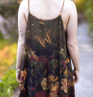 Detail of a butterfly surrounded by small stars on the back of the bodice of a sleeveless floral dress