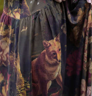 Closeup of a dress skirt featuring a fox among lush florals and some small stars