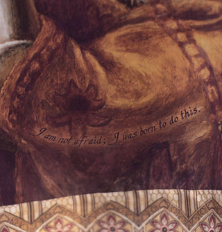 Dress skirt says, "I am not afraid; I was born to do this" near a border of stained glass patterning