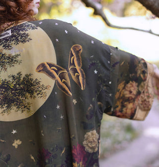 Detail of a butterfly against a full moon on the back of a kimono-style robe with stars and florals throughout