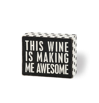 Black and white wooden box sign with polka dot sides says, "This wine is making me awesome" in large white lettering
