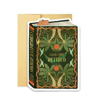Green greeting card in front of a gold envelope with gold-accented palm trees, sun, birds, and hammock designs made to look like a book cover with the words, "Thou Art Retired" printed on the front in gold and, "Congratulations" printed on the spine