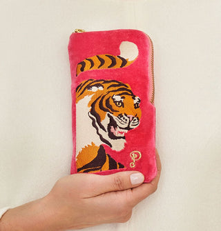 Model's hand holds a rectangular magenta eyeglass case that features an embroidered design of a fierce-looking tiger with its tail curled above its head