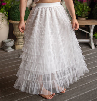 Model wears an ankle-length white tiered tulle skirt with elastic waistband