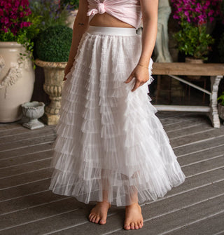 Model wears an ankle-length white tiered tulle skirt with elastic waistband