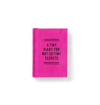 Small hot pink journal hardcover says, "A tiny diary for not-so-tiny secrets" in black lettering between double lines above and below