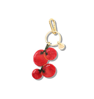 Red acetate tomatoes charm hangs from a gold keyring with round gold tag and lobster clasp attached
