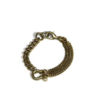 Brass bracelet with thick chain at left and three smaller chains at right, joined by a shackle feature at the bottom and a lobster clasp at the top