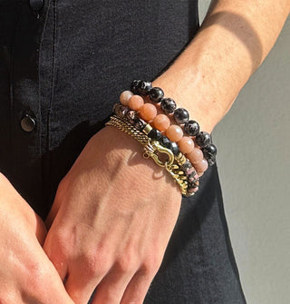 Model wears a mixture of gemstone bead and brass chain bracelets