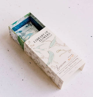 Partially opened sliding box of Library of Flowers True Vanilla Handcreme reveals a rube of product inside