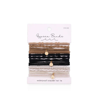 Set of woven Gypsea Bands Waterproof Bracelet Hair Ties in brown, black, and white tones, three of which feature gold charms