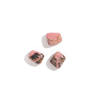 Three pink polished rhodonite stones with varied patterning of black and brown