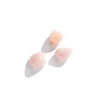 Grouping of three smooth, pink rose quartz stones in varying sizes and shapes