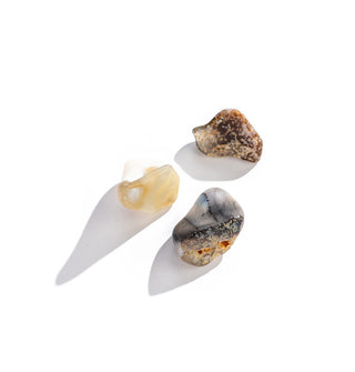 Three tumbled white opal stones in different colorations and shapes