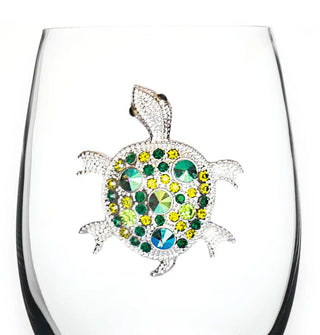 Clear stemless wine glass features a silvery turtle decal adorned with green and blue rhinestones of varying sizes on its shell