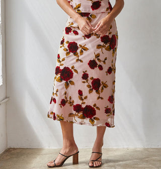 Model weard a light pink sheer lined midi skirt with large red rose print