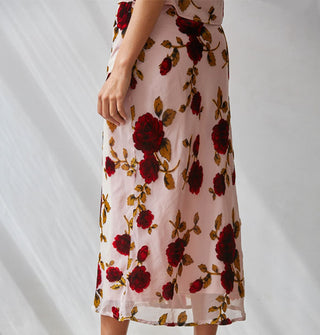 Model weard a light pink sheer lined midi skirt with large red rose print