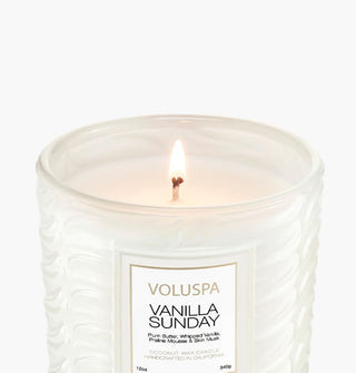 Lit single-wick Vanilla Sunday candle by Voluspa in a frosted white embossed glass vessel