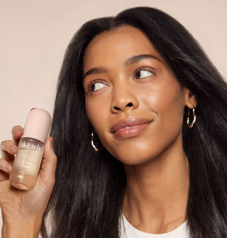Model holds a bottle of Kitsch Warm Sugar Hair Perfume