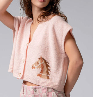 Model wears a light pink short-sleeved V-neck cropped cardigan with three buttons and a bridled brown horse design near the bottom hem