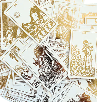 Scattered White Gold Edition tarot cards with gold foil lettering and illustrations