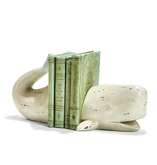 Distressed-effect white sperm whale bookends support a vertical stack of four books with antiqued green covers