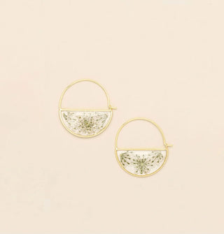Gold hoop earrings with bottom semicircles containing resin-encased pressed white flowers and green stems
