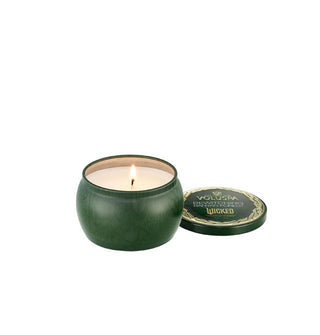 Lit Wicked-themed Voluspa candle in decorative green tin with matching lid removed