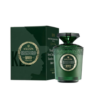 Green glass Wicked-themed Voluspa candle jar with decorative label  and matching box on a white background