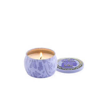 Small purple butterfly and floral print Wicked edition Voluspa candle tin with single lit wick features Glinda's silhouette on the lid which has been removed and set to the side