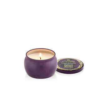 Small dark purple patterned Wicked edition Voluspa candle tin with single lit wick features Elphaba's silhouette on the lid which has been removed and set to the side
