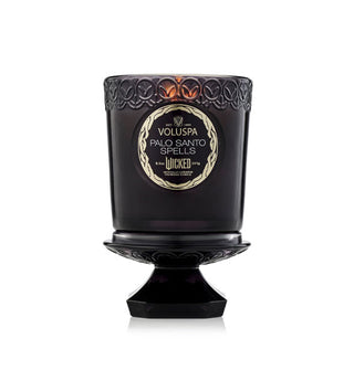Embossed dark purple Wicked edition Palo Santo Spells Voluspa candle jar atop its pedestal-shaped lid
