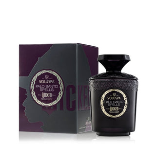 Embossed dark purple Wicked edition Palo Santo Spells Voluspa candle jar with gem-shaped lid handle next to its matching gift box which features Elphaba's silhouette