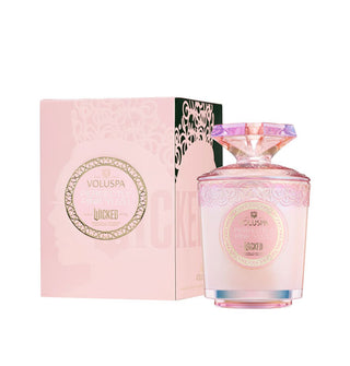 Pink glass Wicked-themed Voluspa candle jar with decorative label  and matching box on a white background