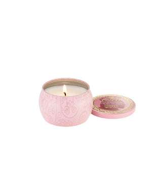 Lit candle in decorative pink Wicked-themed tin with matching lid removed