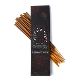 Darkly illustrated rectangular pack of Witch's Rose Minty Rose Botanical Incense is placed atop a bundle of 20 sticks